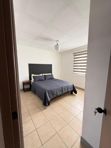 a bedroom with a bed in a white room at Casa con Jacuzzi cerca de Distrito 1 in Chihuahua