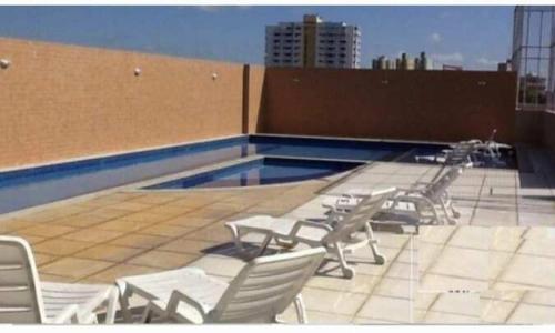 un gruppo di sedie seduto sopra la piscina di Apartamento 2 quartos COP 30 a Belém