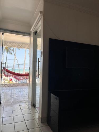 a living room with a fireplace and a view of the ocean at Casa de praia inteira pé na areia Maragogi in Maragogi