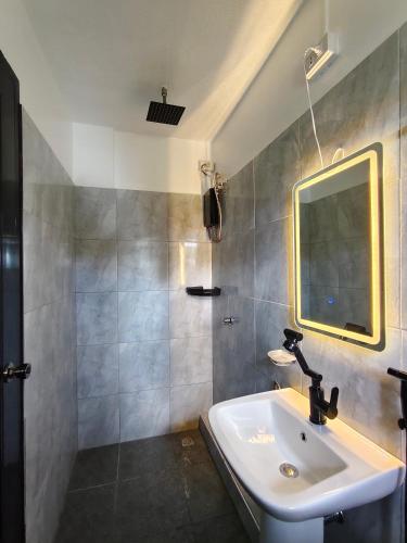 a bathroom with a sink and a mirror at Travis Post Homestay in Siquijor