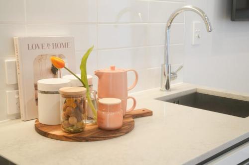 een aanrecht met een dienblad met potten en een gootsteen bij The Urban Nest in Wellington