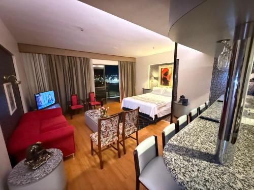 a hotel room with a bed and a red couch at Kubitschek Plaza Hotel - Flat Particular 4 - ALM Hospedagens in Brasília