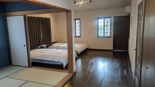a mirror in a room with two beds at HARE 天然温泉かけ流し ビーチ車5分 三段壁近くの閑静な高台 BBQ利用は別料金頂きます GuestHouse HARE in Shirahama