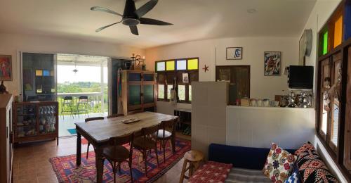 ein Wohnzimmer mit einem Esstisch und einem Deckenventilator in der Unterkunft Stylish Bohemian Getaway with Breathtaking Sea Views in Ko Lanta