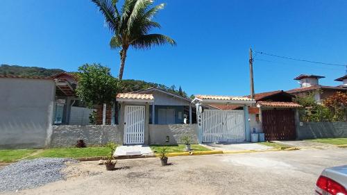 une maison avec un palmier dans l'allée dans l'établissement Encantos do Mar Suites, à Ubatuba