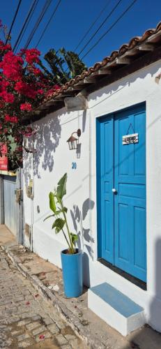 a blue door on a white building with a plant at Suíte Mykonos Canoa Quebrada- Ao lado da Broadway in Aracati