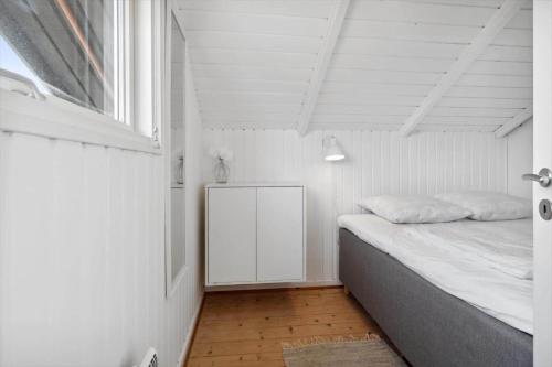ein weißes Schlafzimmer mit einem Bett und einem Fenster in der Unterkunft 0206 Rømø - P S Carlsvej 22 in Tagholm