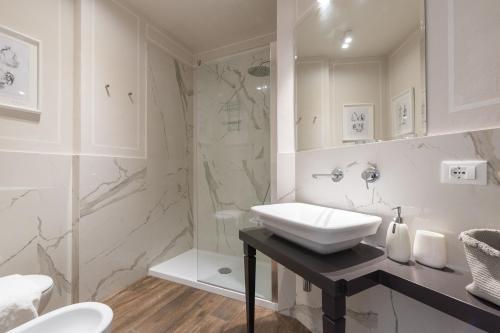 a white bathroom with a sink and a shower at Novella Goldoni Suite-by Florence Concierge in Florence