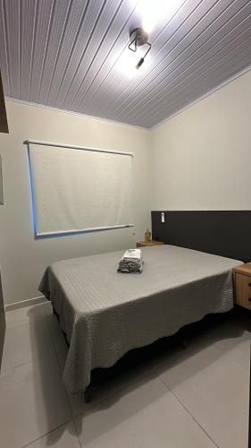 a bedroom with a large bed with a large screen at Casa em Içara Prox Criciúma in Içara