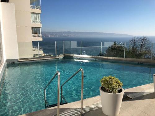 uma grande piscina com vista para o oceano em Maravilhoso Apartamento à beira-mar em Reñaca em Viña del Mar