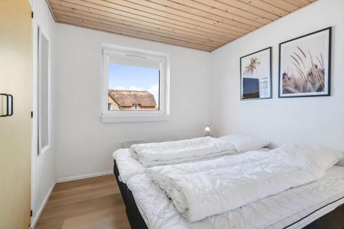 Una habitación blanca con una cama y una ventana en 328-Harboore-Lille-flyvholmvej-14, en Harboør