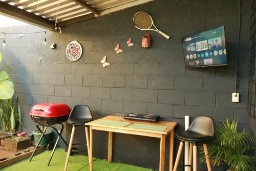 een kamer met krukken, een tafel en een grill bij Las Palmeritas in Ahuachapán