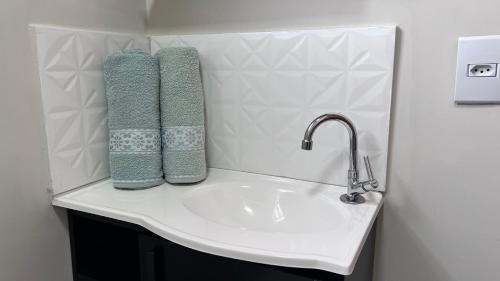 a bathroom sink with two towels on top of it at Apartamento novo próximo a Av do CPA in Cuiabá