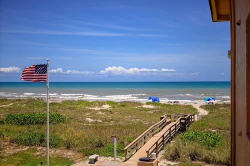 een uitzicht op het strand met een Amerikaanse vlag bij Endless Blue Skies - 2 Bed 2 Bath in Cocoa Beach