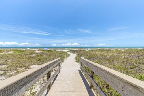 een promenade naar het strand met de oceaan op de achtergrond bij Endless Blue Skies - 2 Bed 2 Bath in Cocoa Beach