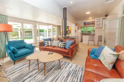 a living room with two couches and a table at Cheltenham Villa in Hanmer Springs