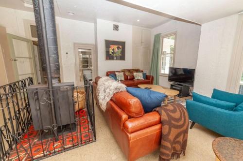 a living room with a leather couch and a television at Cheltenham Villa in Hanmer Springs