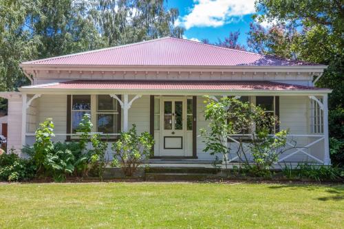 a small white house with a pink roof at Cheltenham Villa in Hanmer Springs
