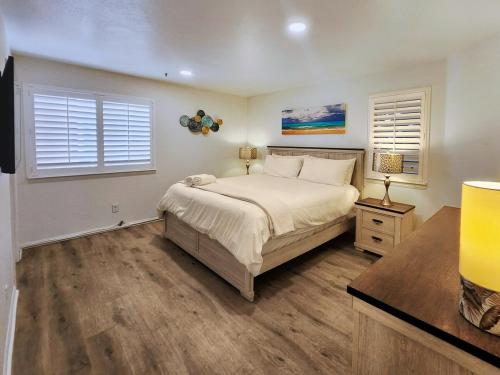 a bedroom with a large bed and two windows at Modern Coastal Escape Breathtaking Ocean in Imperial Beach