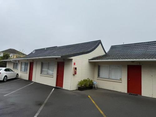 a building with a car parked in a parking lot at Achilles Motel in Christchurch