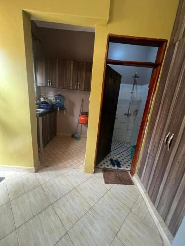 an open door to a kitchen with a shower at Pearl suites - Bukoto in Kampala