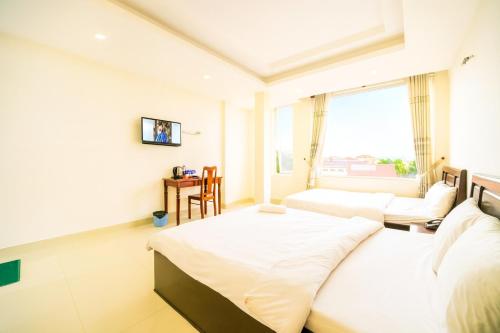 une chambre d'hôtel avec deux lits et une fenêtre dans l'établissement Thành Nghiêm Hotel Ninh Hòa, à Ninh Hòa