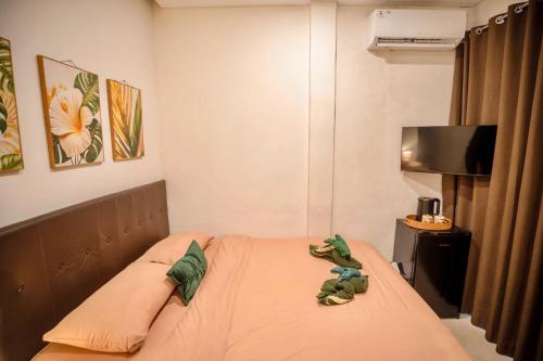 a bedroom with a bed with a stuffed animal on it at Bali Bay By Urban Haven in Sanur