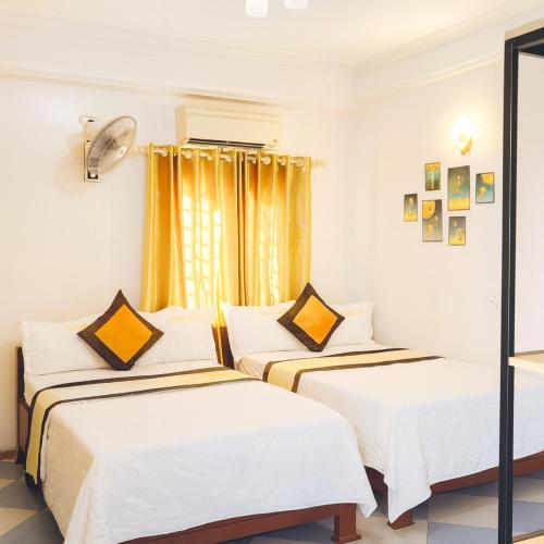 a bedroom with two beds and a window at Thắng Lợi Hotel in Thanh Hóa