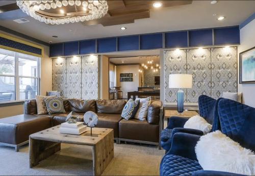 een woonkamer met een bruine bank en blauwe stoelen bij The Nash Luxe, Pool, Gym, Nightlife! in Nashville