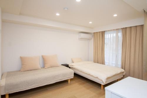a bedroom with two beds and a window at M House 301 Tokyo Omori駅 in Tokyo