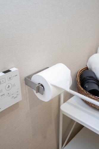 a roll of toilet paper hanging on a wall at M House 301 Tokyo Omori駅 in Tokyo