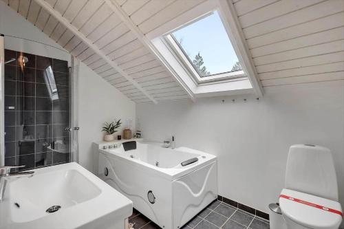 ブラーバンドにあるBV287-Blavand-Soren-Lassens-Vaenge-11のバスルーム(大きな白いバスタブ、窓付)