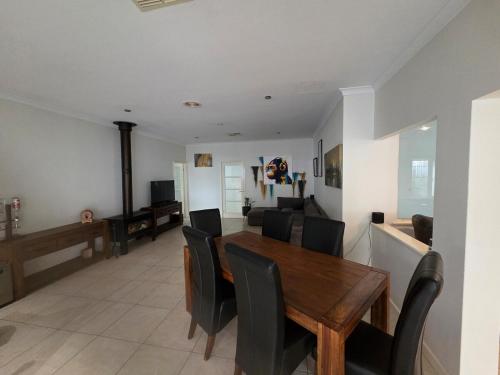a dining room and living room with a wooden table and chairs at 4 bed House next to Lake Richmond close to beach in Rockingham