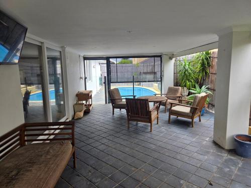 a patio with a table and chairs and a pool at 4 bed House next to Lake Richmond close to beach in Rockingham