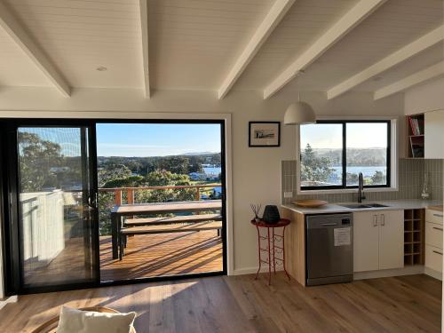 a kitchen with large windows and a view of a deck at Chilltown Burrill Lake in Burrill Lake