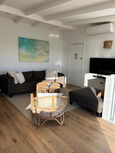 a living room with a couch and a table at Chilltown Burrill Lake in Burrill Lake