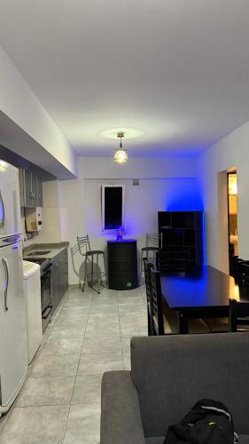 Una cocina y una sala de estar con una mesa y un sofá. en Departamento Norte 1, en San Salvador de Jujuy