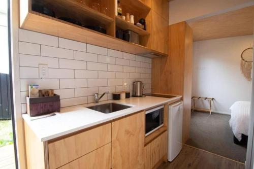 a small kitchen with a sink and a microwave at The Dunes at Fitzroy Beach in New Plymouth