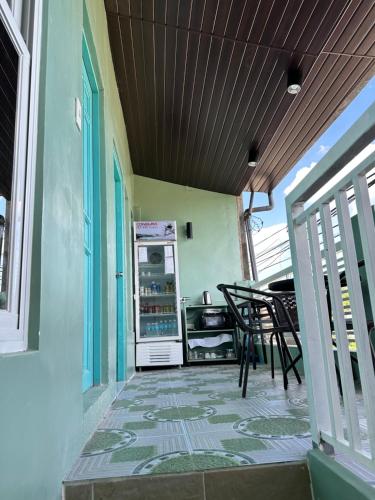 een veranda met een koelkast en een tafel en stoelen bij SJ Vistacation in Tanza