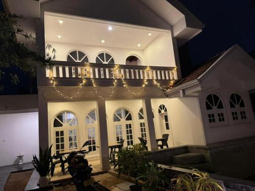 una grande casa bianca con un balcone illuminato di Theodore Hotel - Negombo a Negombo