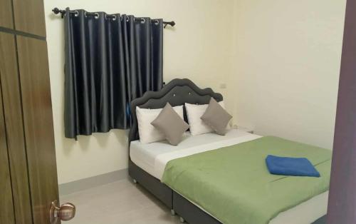 a small bedroom with a bed and a window at Tranquility House in Ko Lanta