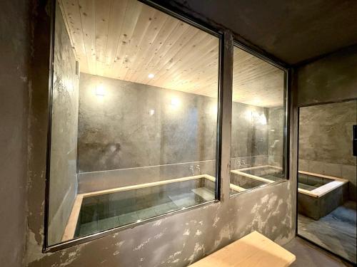 a bathroom with a shower with a glass window at 箱根強羅 縁 in Hakone