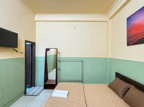 een slaapkamer met een bed en een tv aan de muur bij An Homestay CN2 in Ấp Bình Hưng