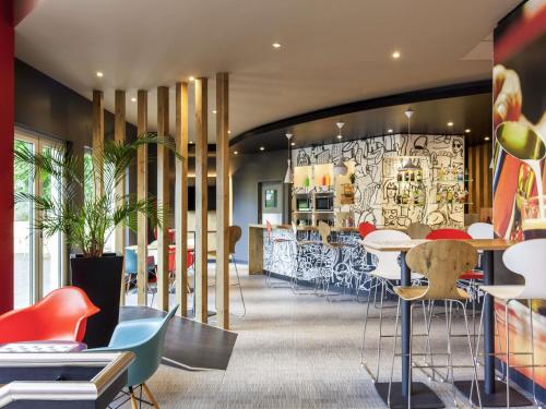 a restaurant with colorful chairs and tables and a bar at Hotel ibis Lisboa Jose Malhoa in Lisbon
