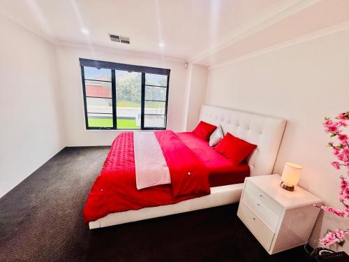 a white bedroom with a red bed and a window at Modern King Suite on Swan Valley Doorstep in West Swan