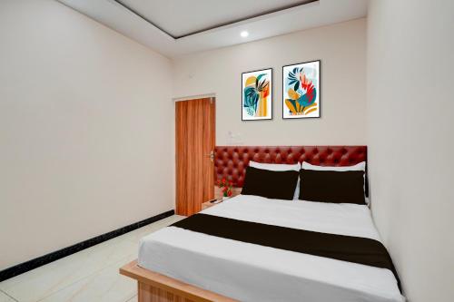 a bedroom with a large bed with a red headboard at Super Hotel O Kachohalli Gate Formerly SRS Lodge in Tāvarikere