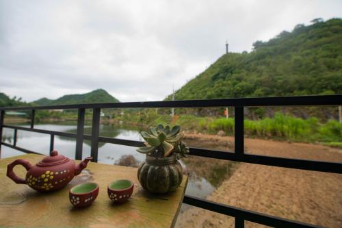 a table with tea pots and cups on a balcony at Homestay Quản Thanh in Loung Co