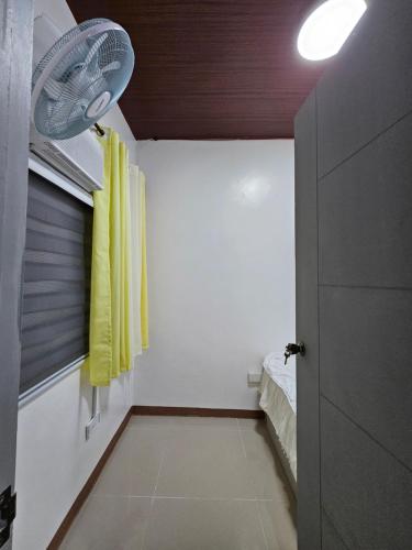 a hallway with yellow curtains and a room with a bed at The Roam Inn - Fast Wifi Connection in Dipolog