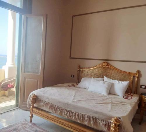 a bed with white sheets and pillows in a bedroom at Ivy hotel in Alexandria