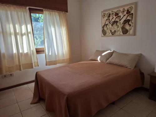 Un dormitorio con una cama y una ventana en Casa en Piriápolis para ocho personas grande y luminosa, en Piriápolis